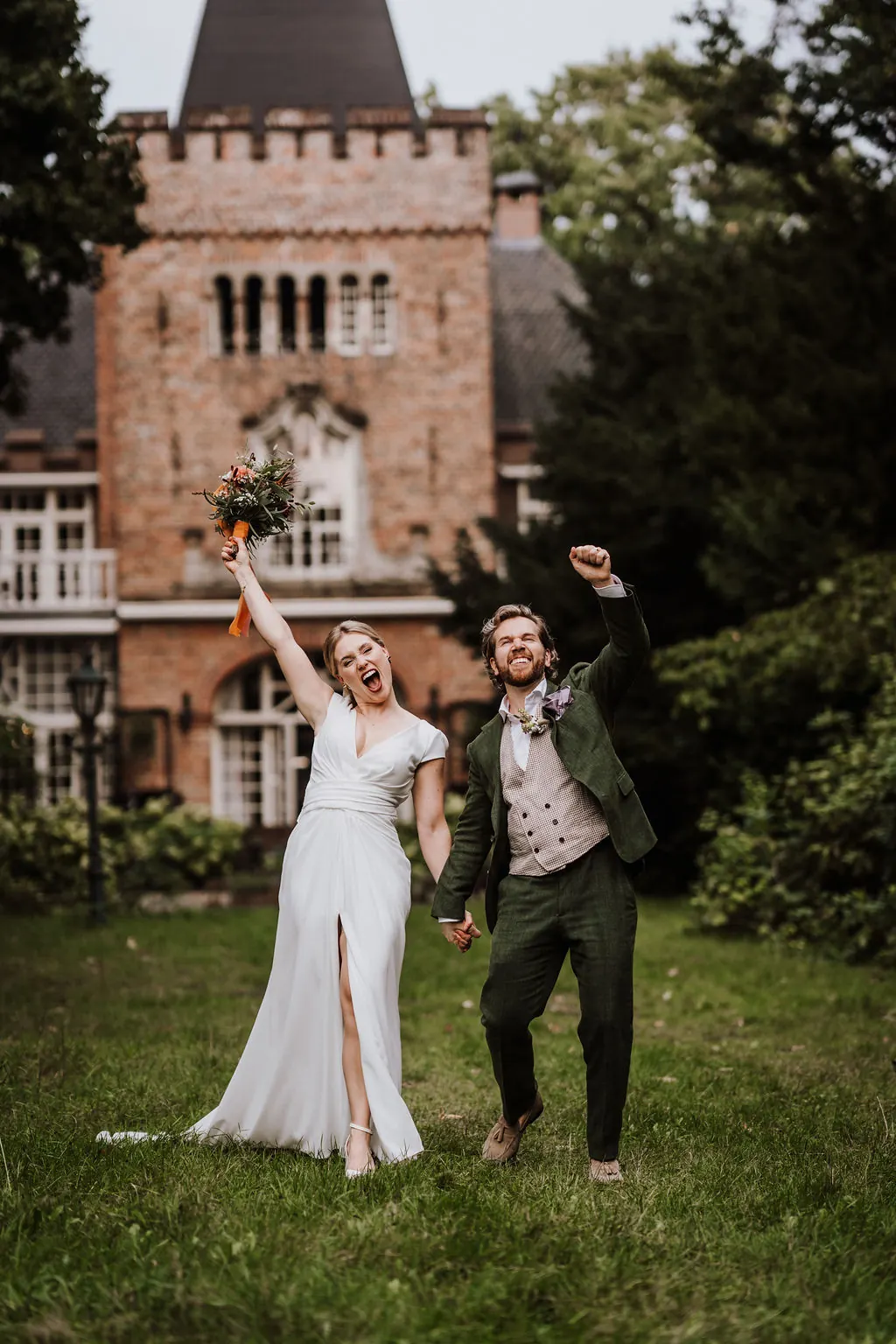 Bruidspaar Joe en Anne juichend bij kasteel